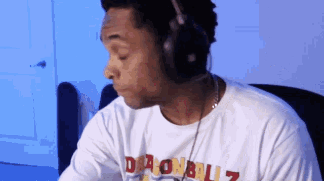 a man wearing headphones and a white shirt that says dragonblitz
