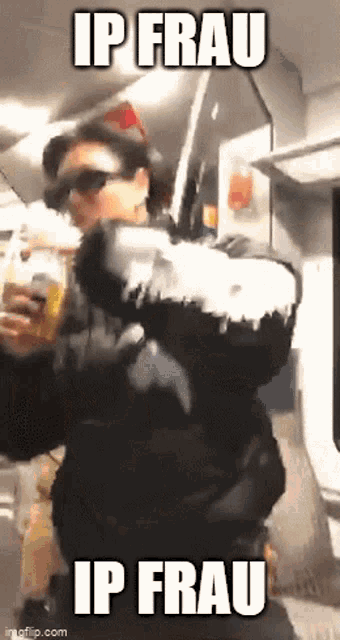 a man in a black jacket is holding a bottle of beer and says ip frau ip frau