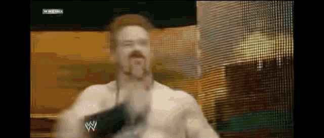 a man without a shirt is wearing a wwe glove