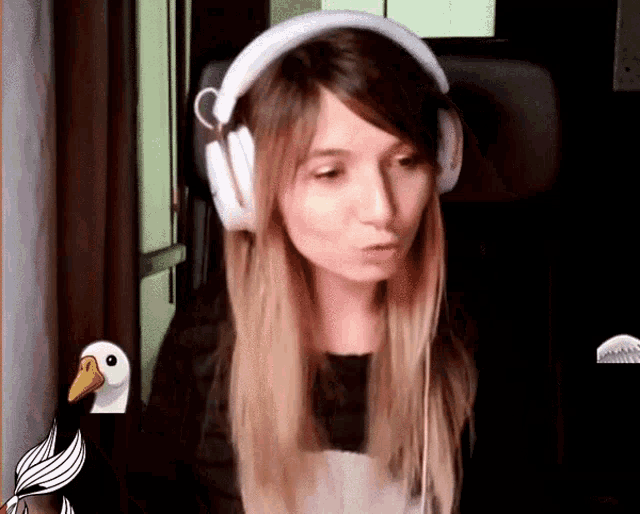 a woman wearing headphones and a black shirt is sitting in front of a computer .