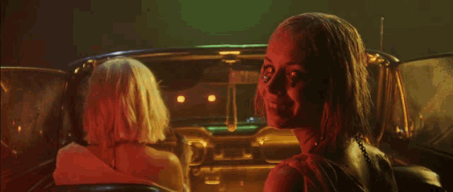 two women are sitting in a car with a license plate that says ' jl ' on it