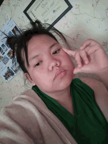 a girl laying on a bed with a framed certificate of achievement