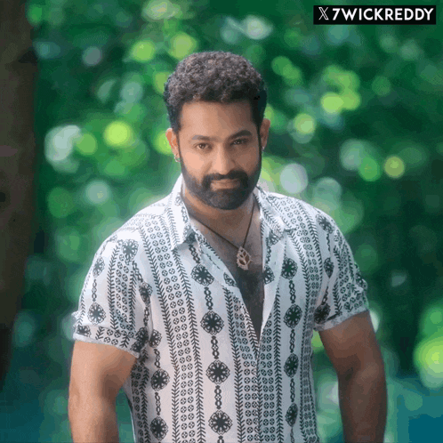 a man with a beard wearing a white shirt with a black pattern