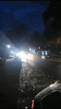 a car is driving down a street at night with a blurred background