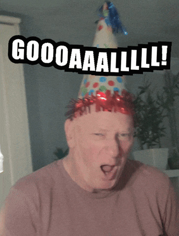 a man wearing a party hat with the words goooaaalll written on it