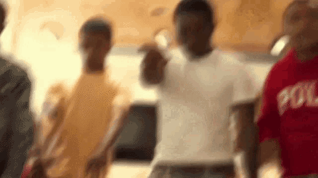 a group of young men are standing in a room holding hands .