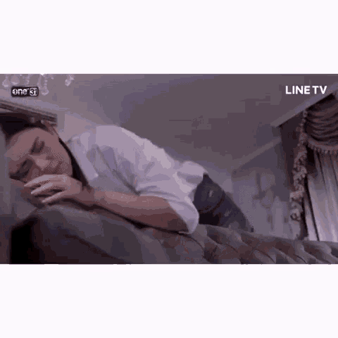 a woman is laying on a couch with her head on a pillow .