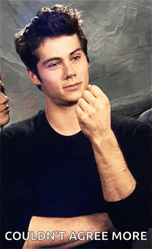 a man in a black shirt is holding his hand to his chin and says could n't agree more