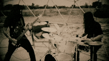 a black and white photo of a man playing a guitar