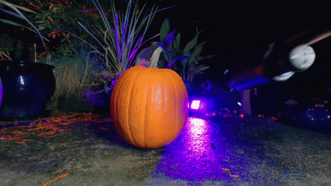 a pumpkin is lit up with purple lights in the background
