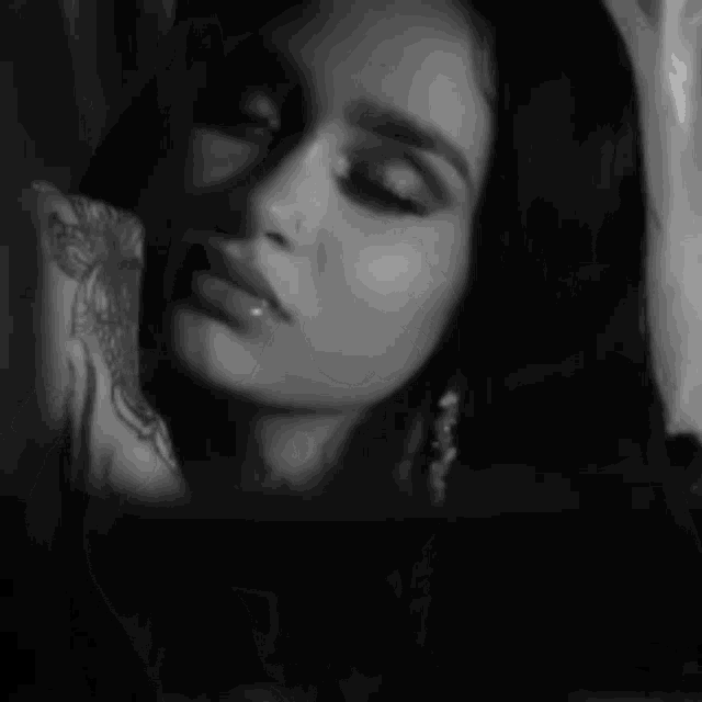 a black and white photo of a woman with a tattoo on her arm that says louis