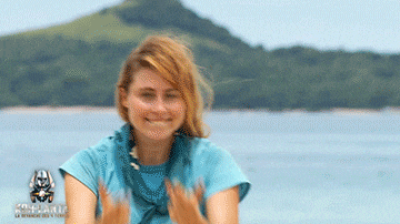 a woman in a blue shirt is clapping her hands