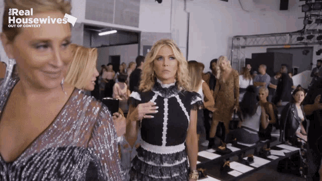a woman in a black and white dress walks down a runway with the words real housewives out of context