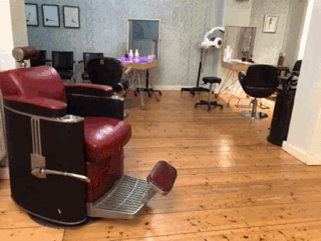 a red barber chair sits in the middle of a hair salon