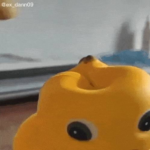 a close up of a yellow stuffed animal with a sad face .