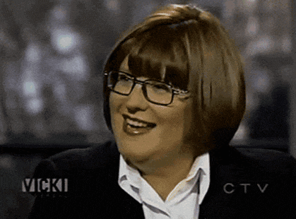a woman wearing glasses and a black jacket is smiling on a ctv show