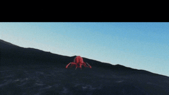 a red spider is sitting on top of a hill