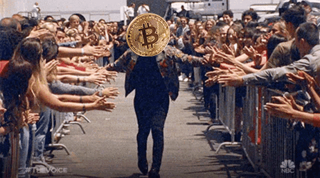 a man carrying a coin with the letter b on it walks through a crowd of people