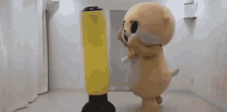 a stuffed animal is hitting a punching bag in a room .