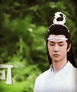 a man with a dragon on his head is wearing a white shirt and a white headband