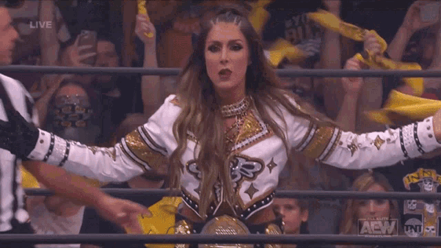 a woman in a wrestling ring with a tnt logo on the bottom right