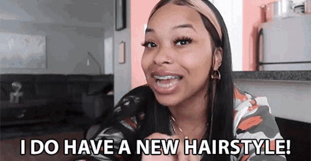 a woman is wearing a headband and smiling while talking about her new hairstyle .
