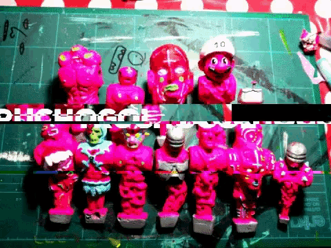 a bunch of pink toys are sitting on a green cutting board