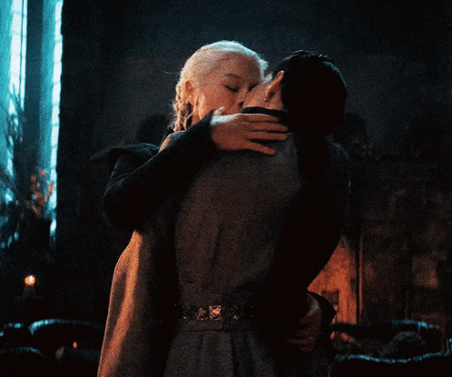 a man and a woman kissing in a dark room