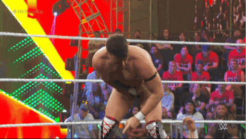 a man in a wrestling ring with the letters w on his chest