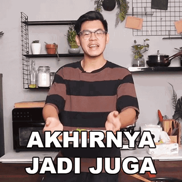 a man in a kitchen with the words akhirnya jadi juga written on the screen