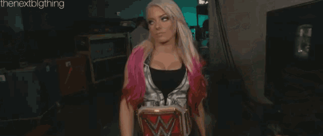 a woman with blonde hair and pink highlights is holding a championship belt .