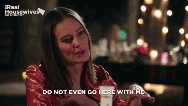 a woman says " do not even go here with me " while sitting at a table
