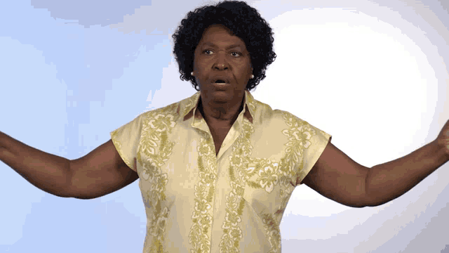 a woman in a yellow shirt has her arms wide open