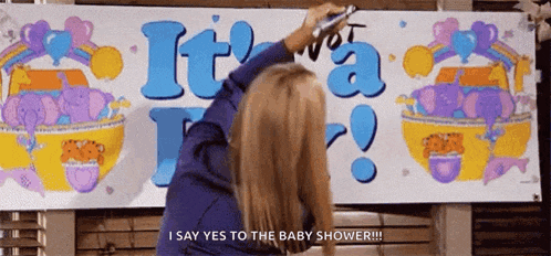 a woman is writing on a sign that says it 's not a boy