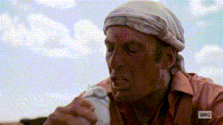 a man with a bandana on his head is drinking from a plastic bottle .