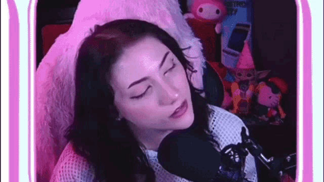 a woman is sitting in front of a microphone and making a face .