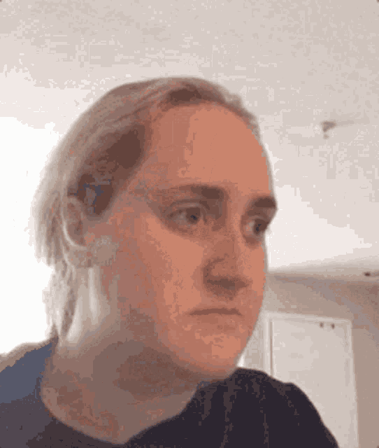 a woman is making a funny face with her eyes closed .