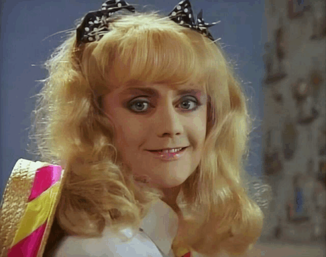 a woman with blonde hair and a black bow on her head