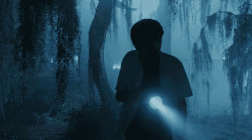 a person holding a flashlight in the dark