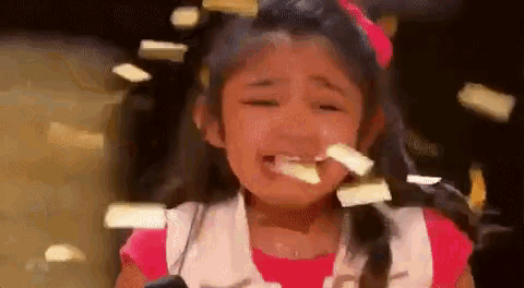 a little girl is crying with confetti falling on her face
