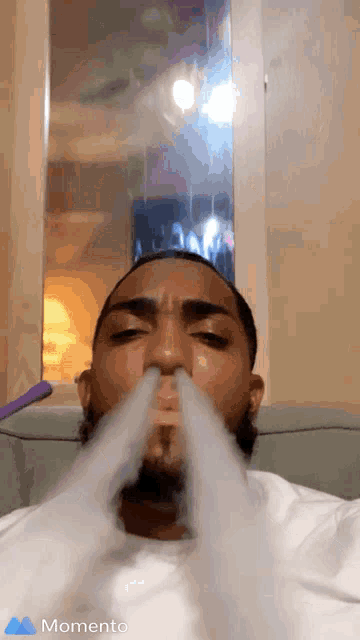 a man is smoking a hookah and the word momento is on the bottom right