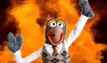 a stuffed animal is standing in front of a fire .