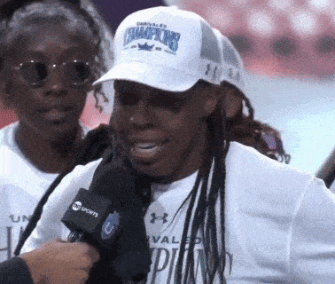 a woman wearing a white hat that says champions on it