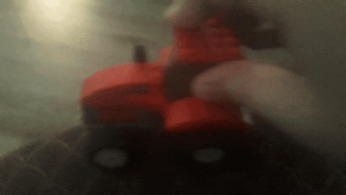 a blurred image of a person holding a red item