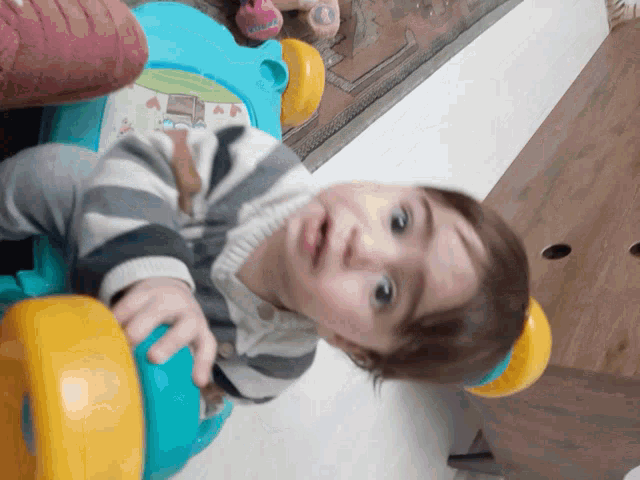 a little boy is playing with a toy that has a house on it