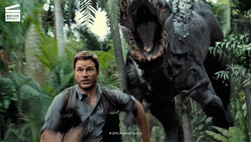 a man is running from a dinosaur in a scene from a movie called jurassic world