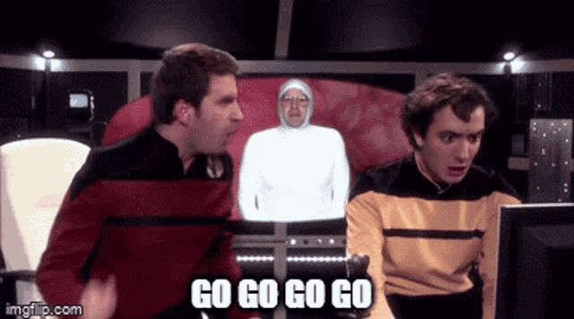 two men are looking at a computer screen with the words go go go go written on the bottom