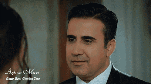 a man in a suit and tie looks at a woman with the words aşk ve mavi on the bottom right