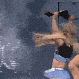 a woman in a crop top and shorts is holding a trophy over her head