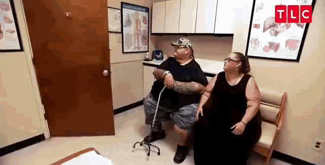 a man and a woman are sitting on a bench in a room .